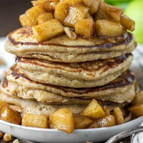 apple ricotta pancakes stacked on top of each other on white plate