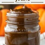close-up of pumpkin jam in mason jar with pumpkins in background