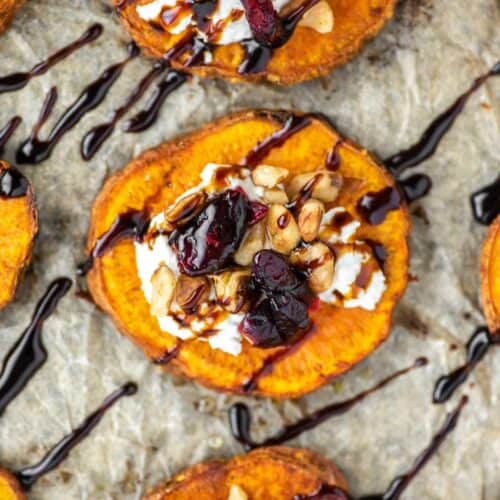 overhead shot of sweet potato rounds with goat cheese, walnuts, cranberries and balsamic vinegar