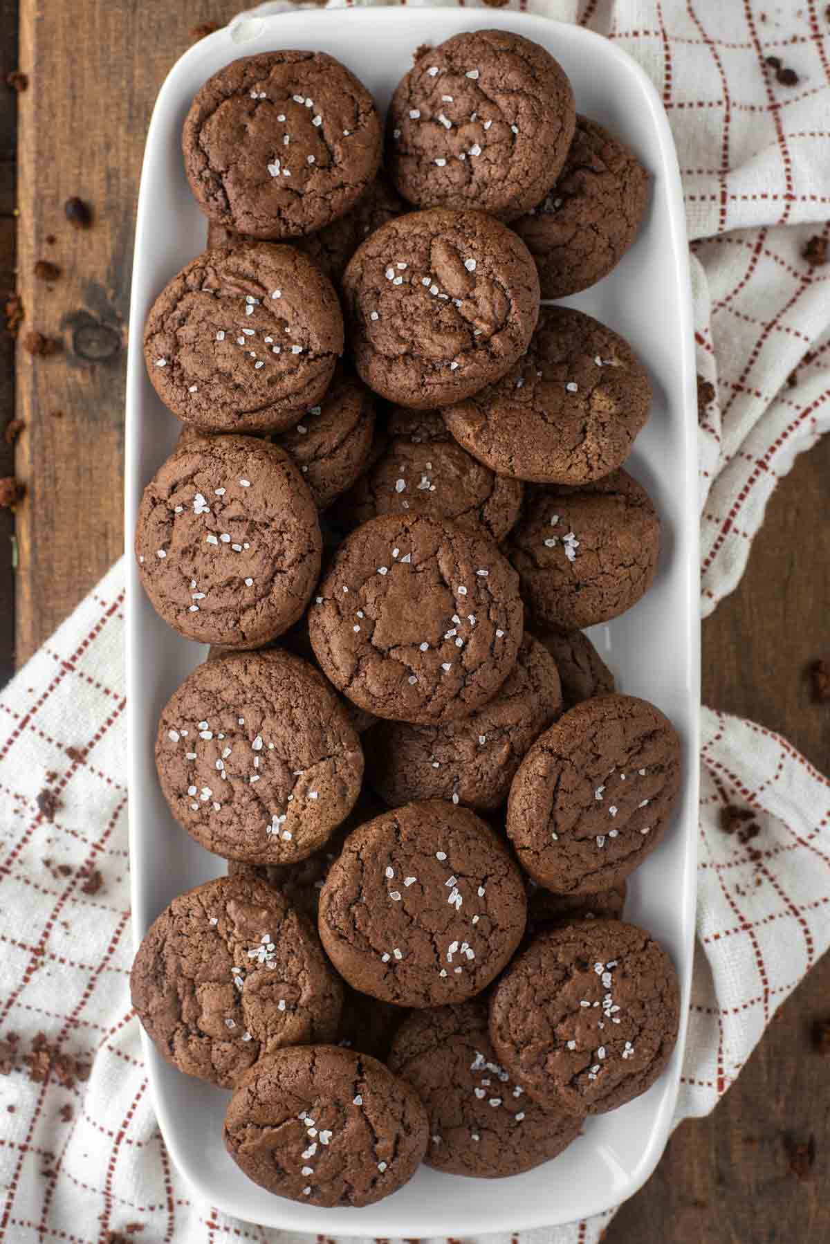 overhead shot of brownie crinkle cookies on white plate