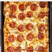 chicken pepperoni pizza on sheet pan and sliced