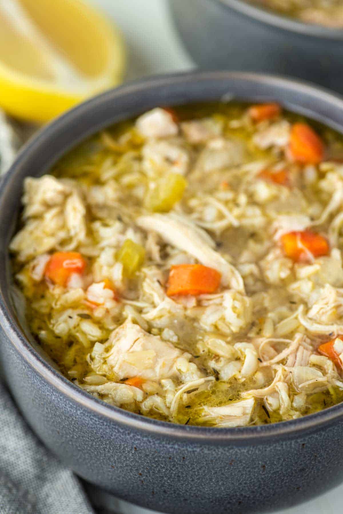 close-up of chicken and rice soup in grey bowl