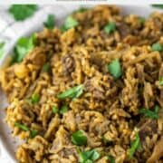 close-up of fork lifting beef biryani off of plate