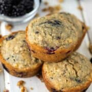 close-up of blackberry oatmeal muffin stacked on top of 3 others
