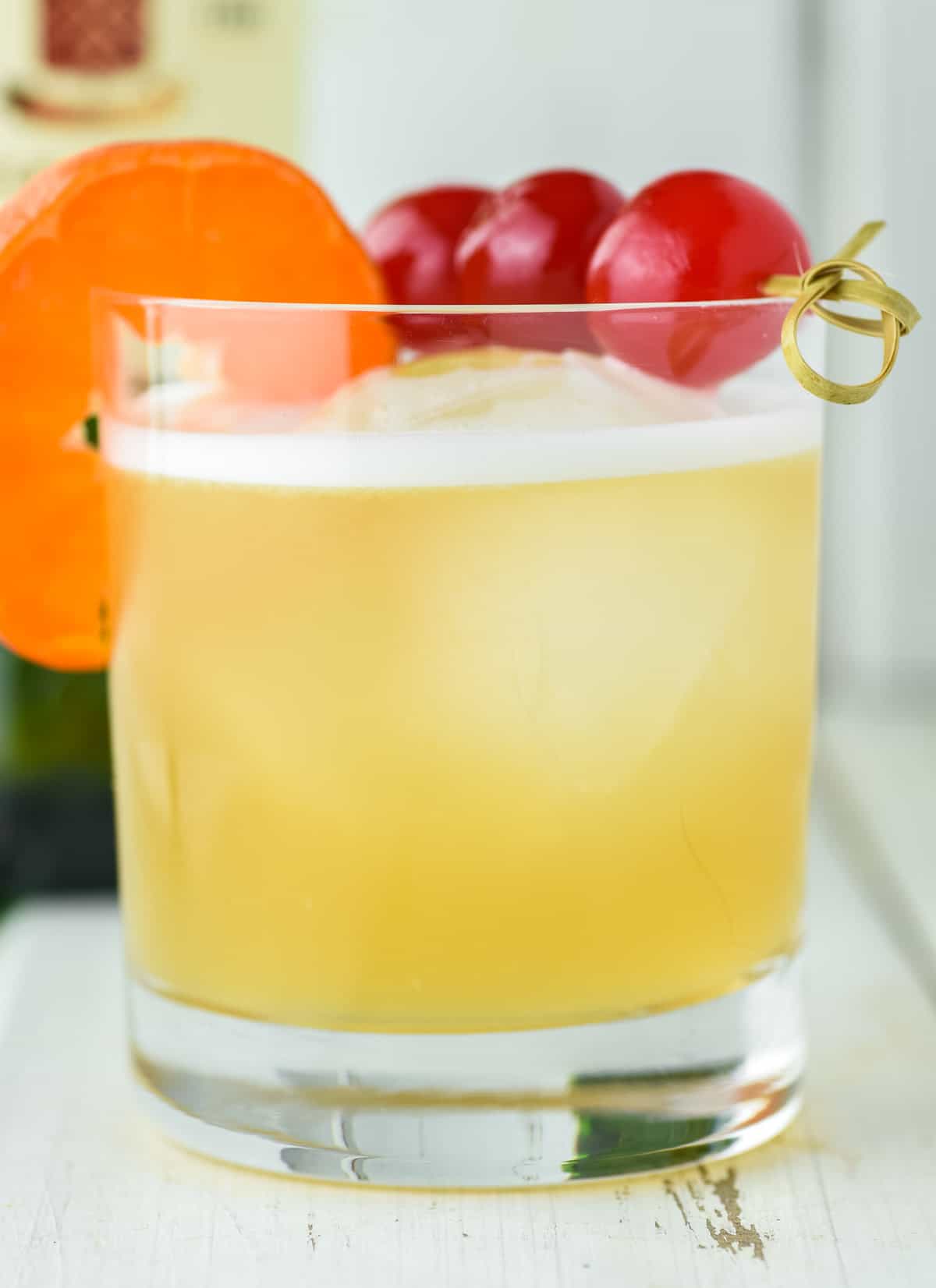 old fashioned glass of Jameson whiskey sour with cherries and orange slice as garnish