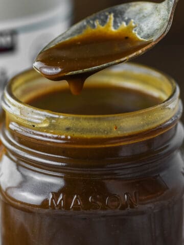 spoon lifting out maple balsamic dressing from glass