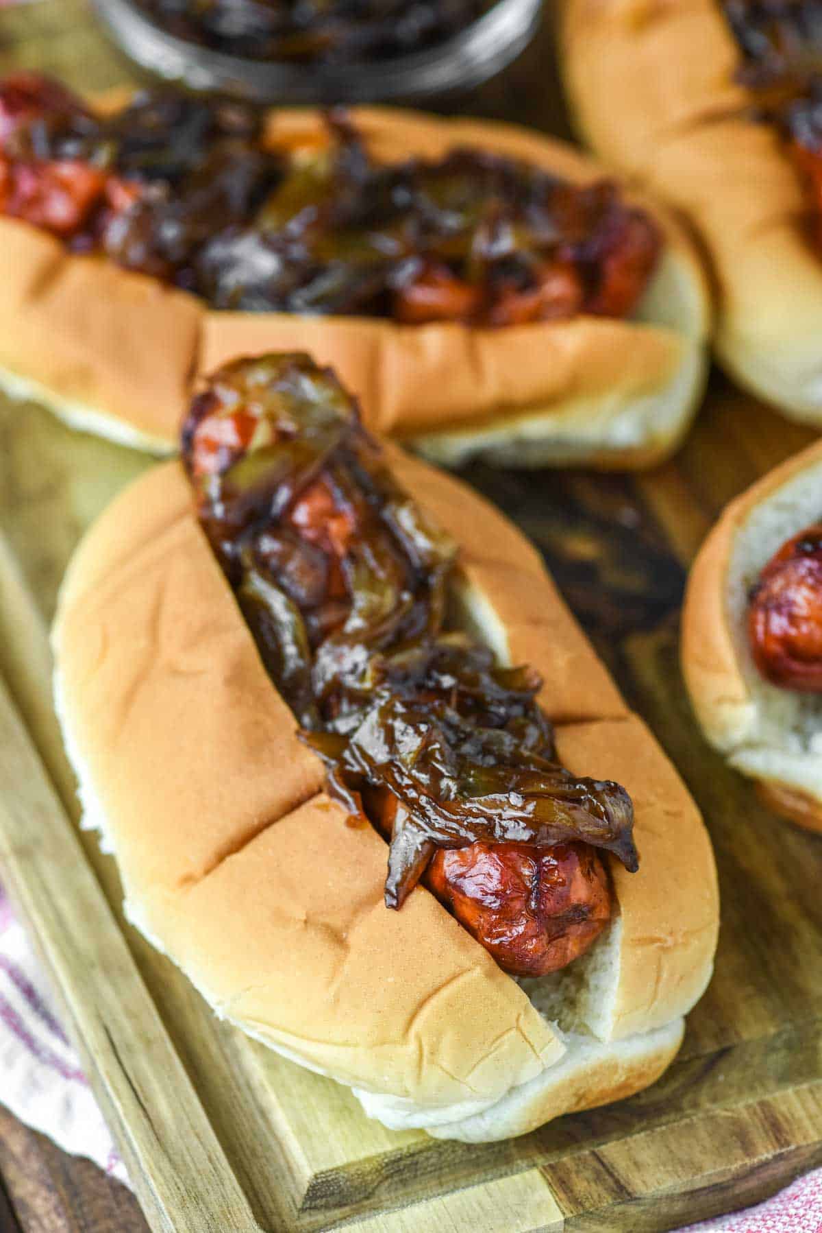 close-up of smoked brats with beer onions on wood board