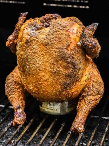 smoked chicken sitting on beer in smoker