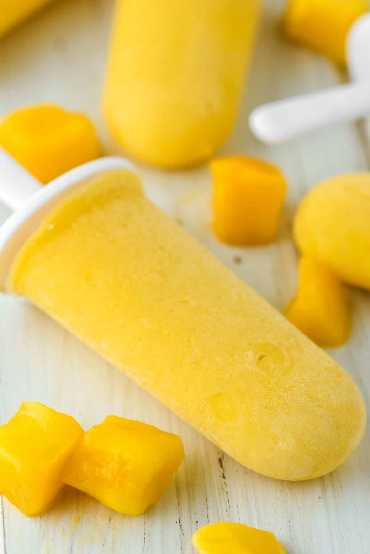 close-up of mango popsicles on white board