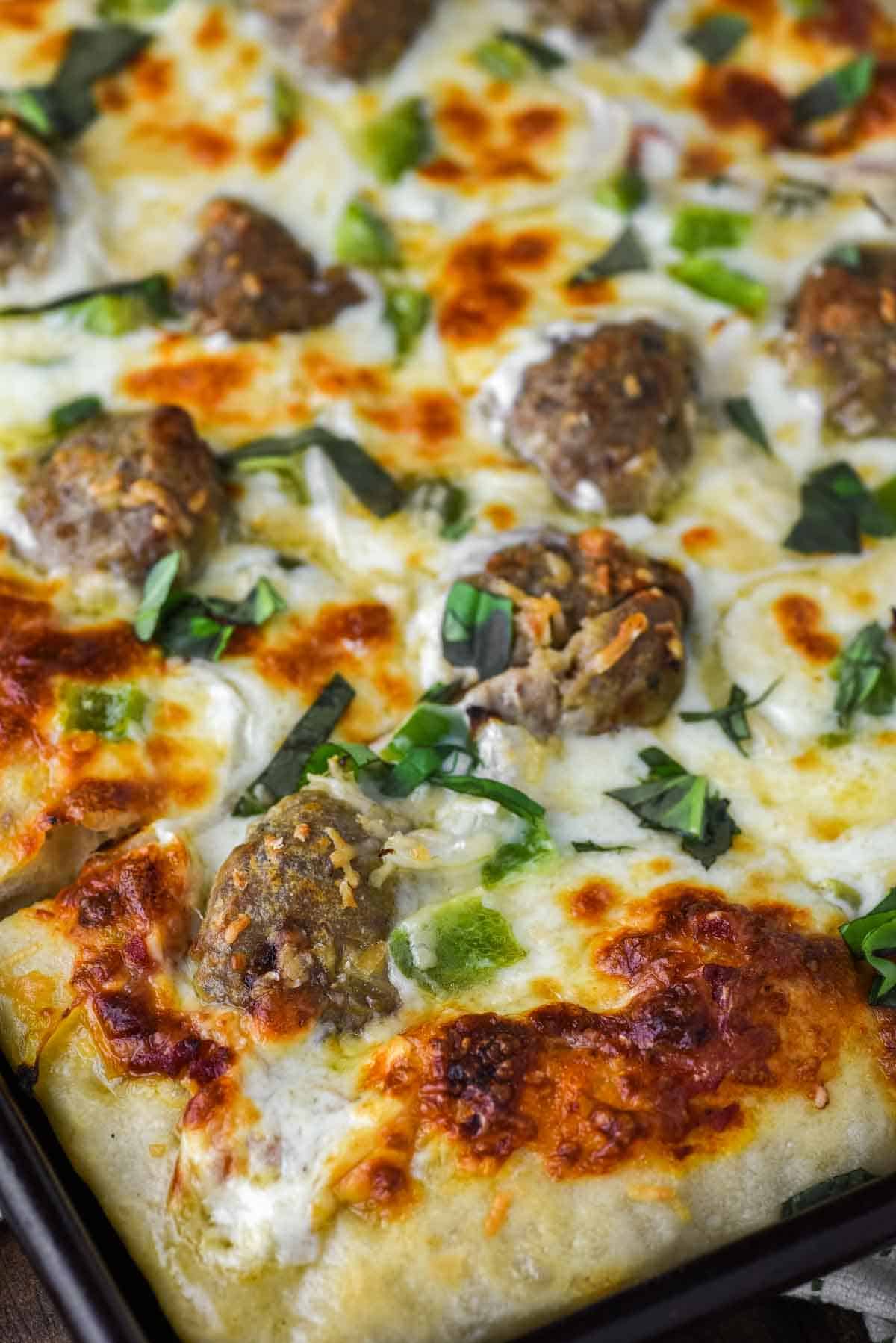close-up of meatball pizza in baking sheet