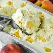 ice cream scoop scooping out peaches and cream ice cream in metal tin