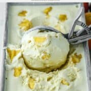 close-up of ice cream scoop scooping out peaches and cream ice cream in metal tin