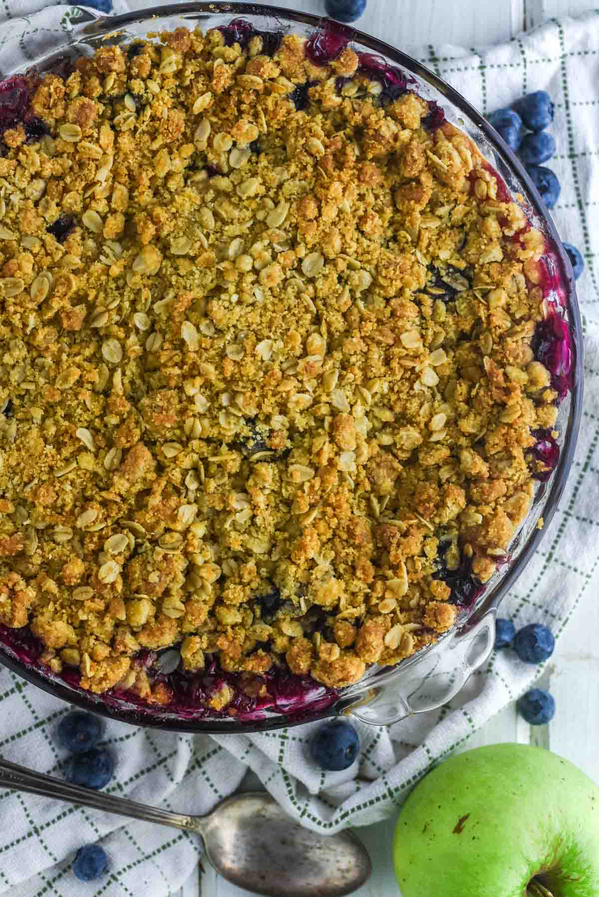 overhead shot of glass pie dish filled with apples and blueberries and a crumble topping