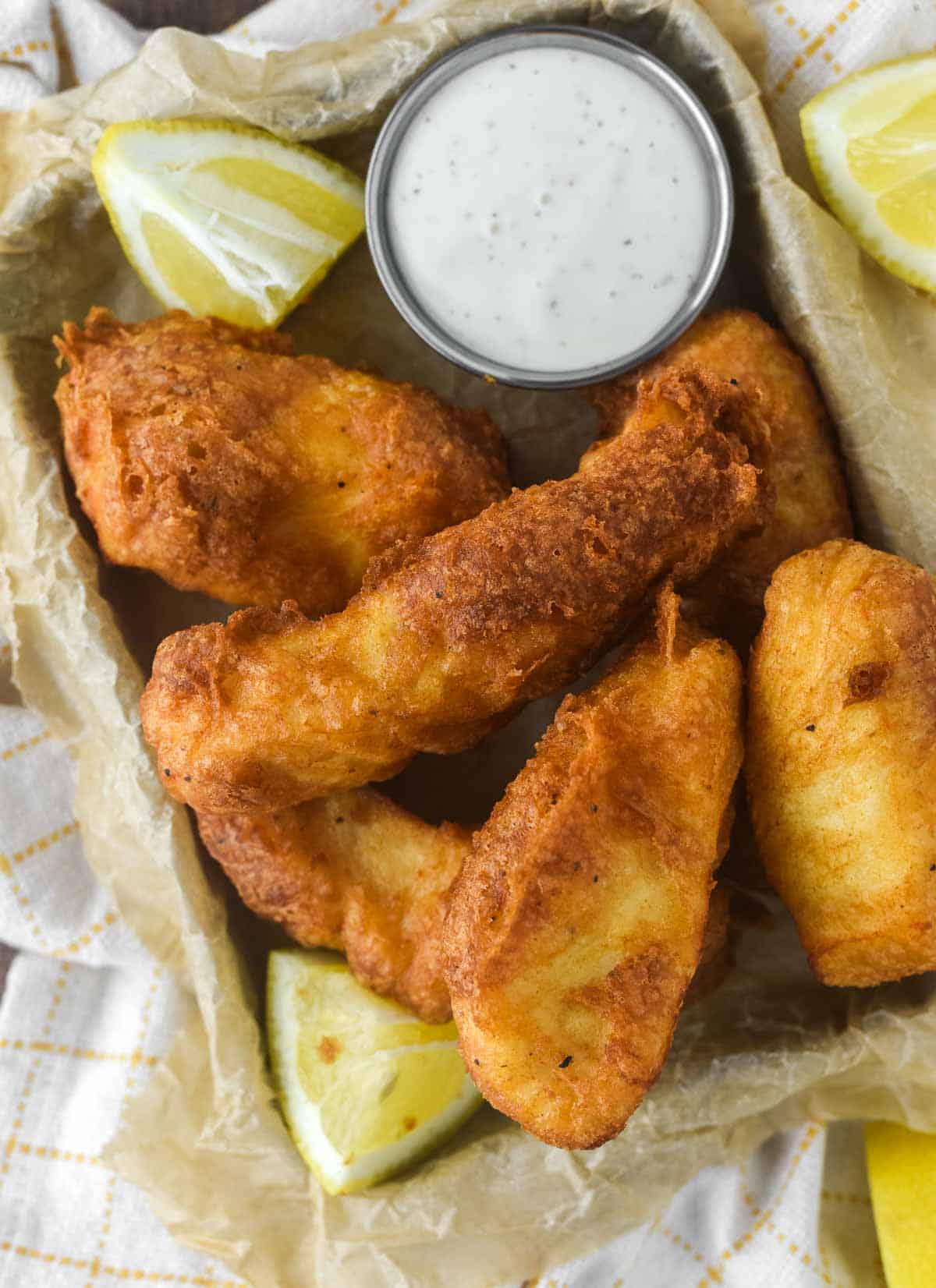 overhead shot of parchment-lined tin filled with beer battered halibut