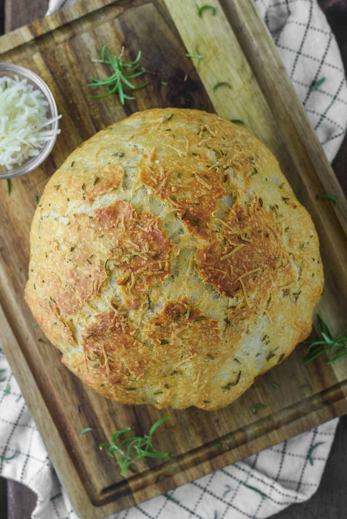 overhead shot of rosemary parmesan bread on wood cutting board