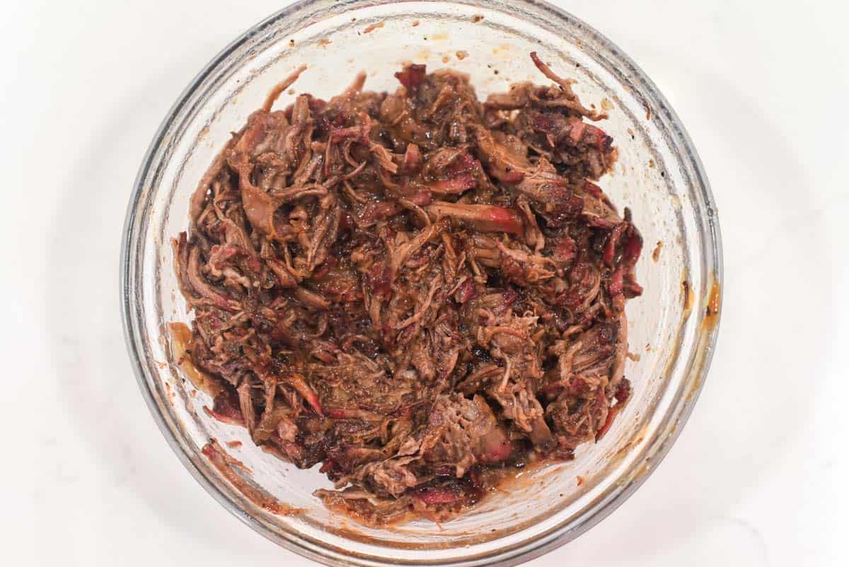 process shots of tossing pulled beef in BBQ sauce