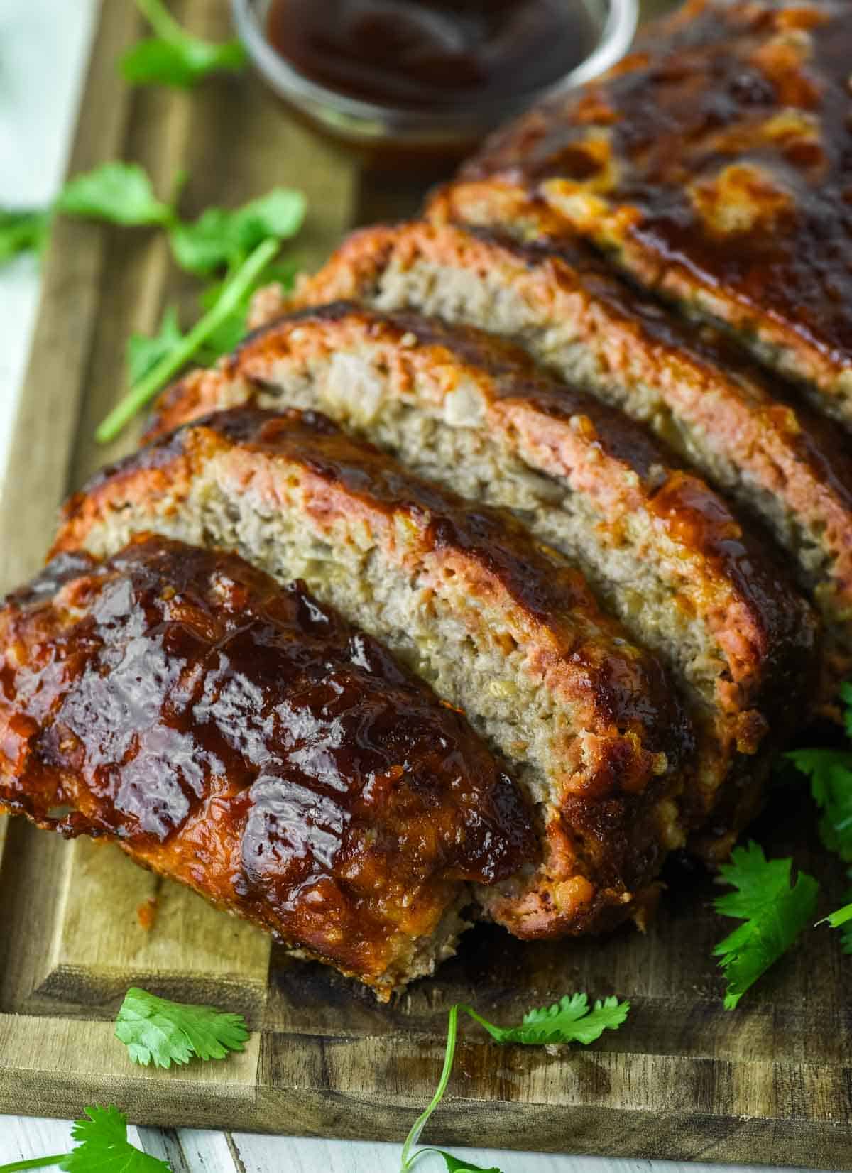 sliced smoked meatloaf on wood cutting board