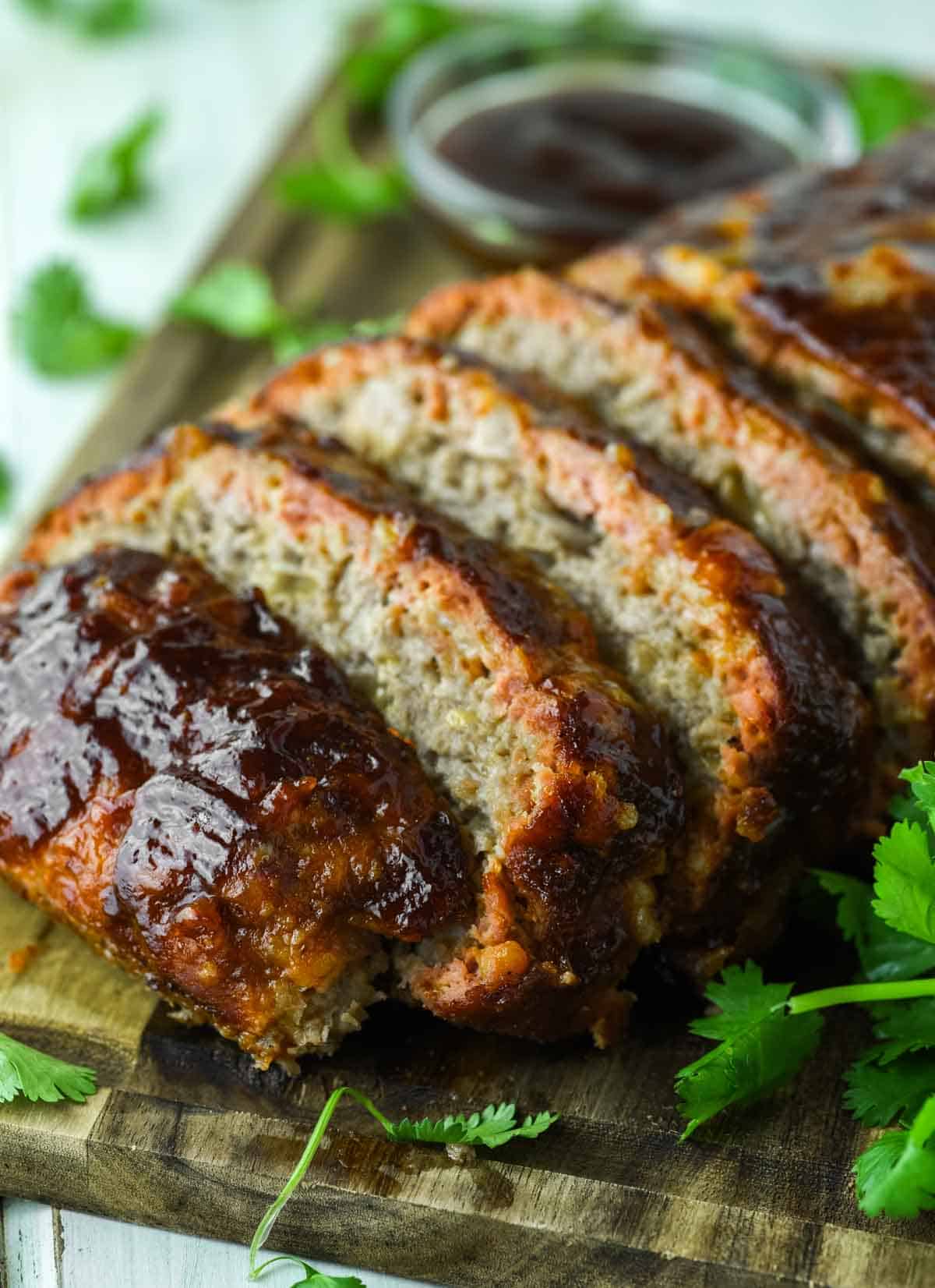 slices of smoked meatloaf on cutting board with cilantro