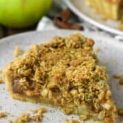 slice of apple crumble tart on speckled plate