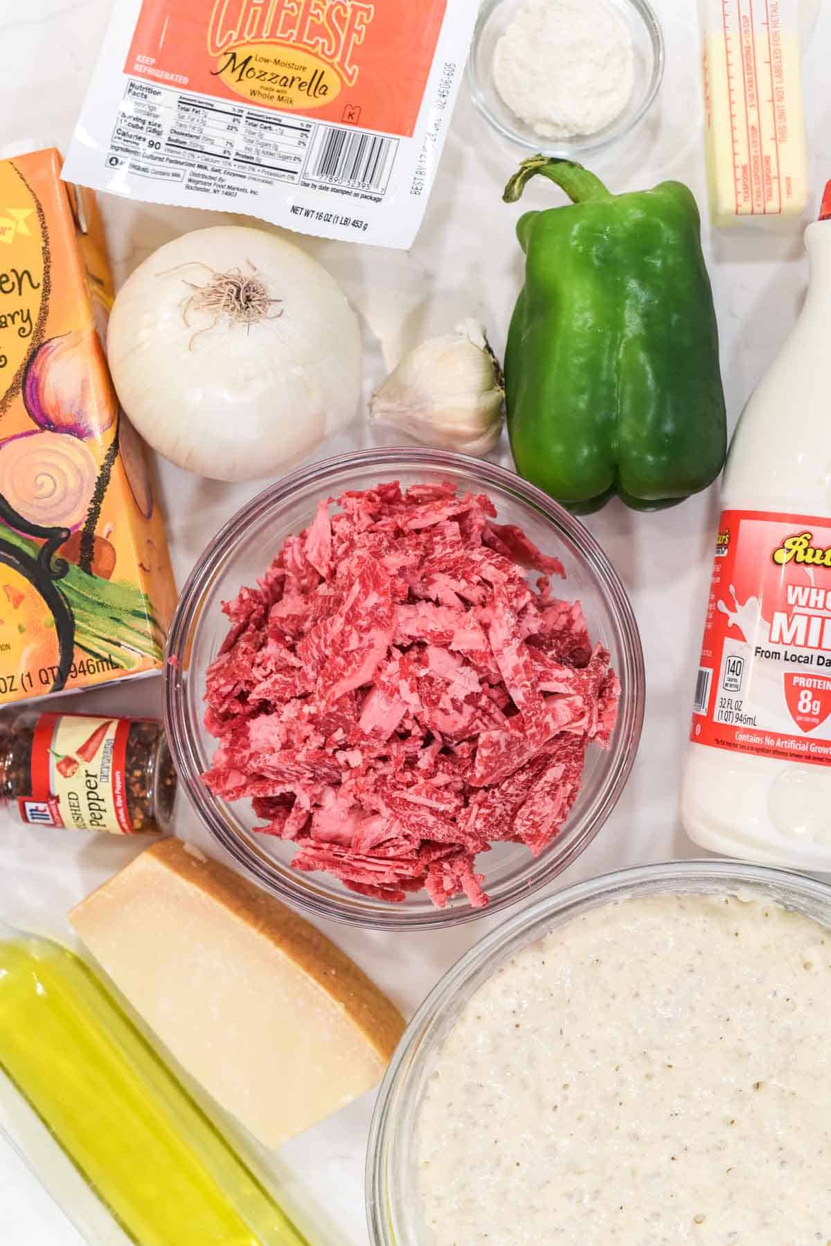 overhead shot of ingredients for philly cheesesteak pizza