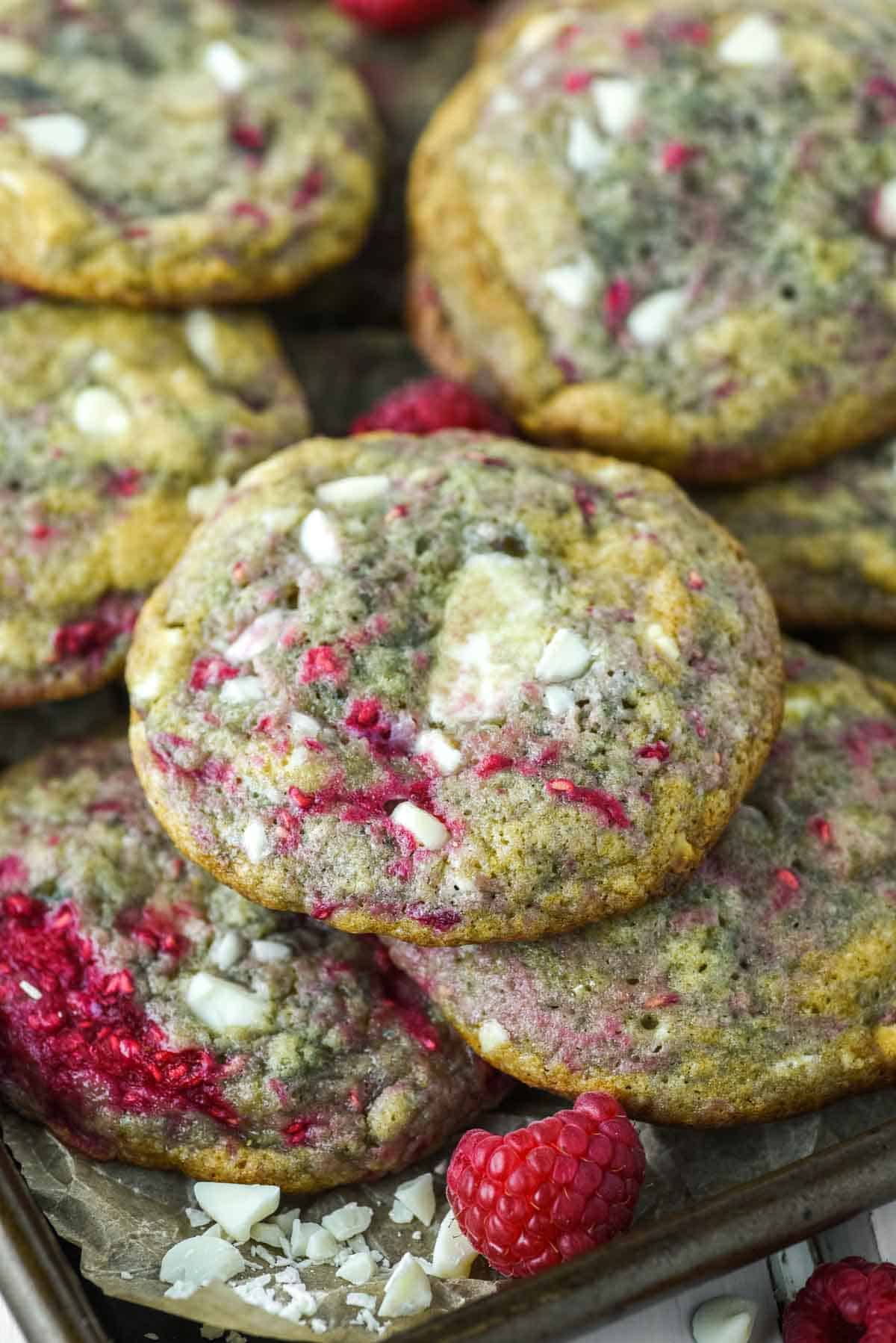 close-up of white chocolate raspberry cookies stacked on baking sheet