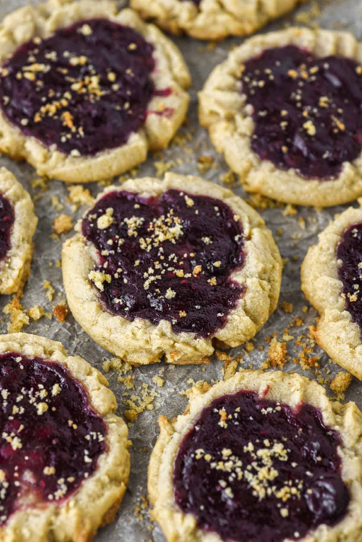 close-up of peanut butter and jelly cookies on parchment-lined baking sheet
