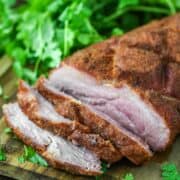 close-up of sliced smoked pork loin on cutting board