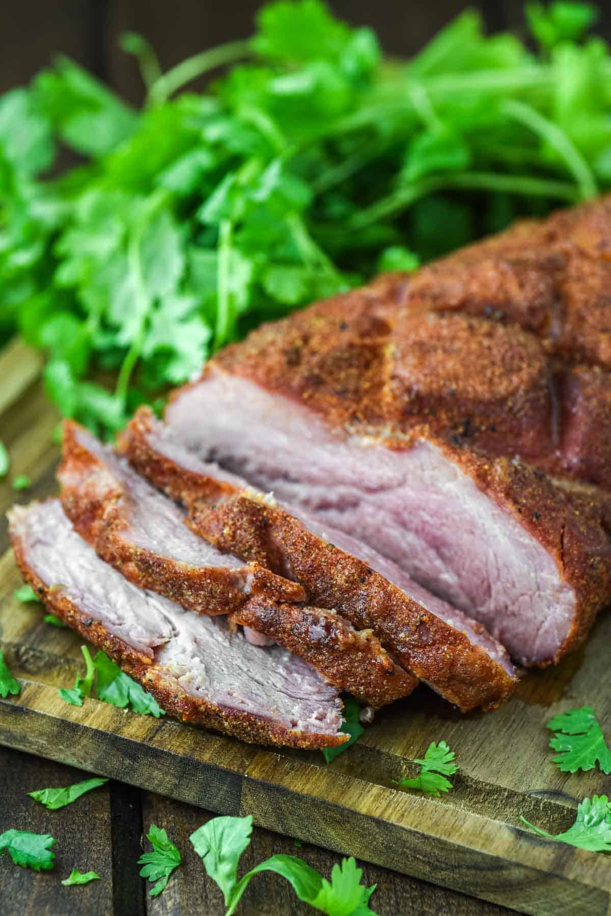close-up of sliced smoked pork loin on cutting board