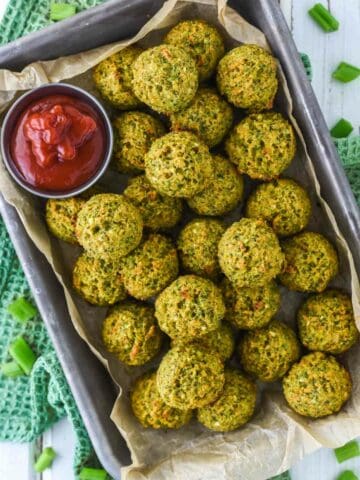 overhead shot of broccoli bites in parchment-lined tin