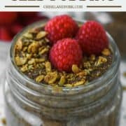 close-up of chocolate chia seed pudding in glass jar with raspberries and granola on top