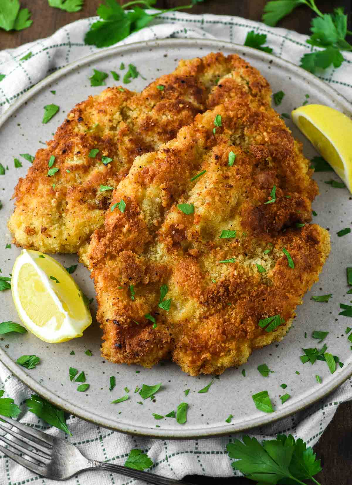 chicken schnitzel on speckled plate with lemon
