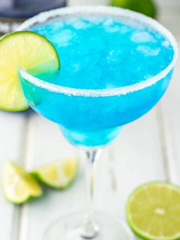 blue margarita with limes on white board